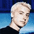 Pixelated static image of a person with light hair against blue background wearing dark clothing