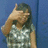 A pixelated figure with long dark hair covers their face with one hand against a solid blue background.