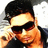 Pixelated image of a person with dark hair wearing black sunglasses and a dark shirt, holding an object near their face.