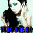 Pixelated image of a person with dark hair and blue eyes wearing black clothing, holding an object near their face against a light background with text at the bottom.