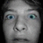Pixelated grayscale face with wide eyes on black background, yellow text 'FLYING' top-right and 'JESUS BARBIE <3' bottom-center.