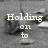 A grayscale animated image with pixelated text reading 'Holding on to Every Little dear memory of the most incredible summer' over a blurred background.