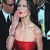 A pixelated figure in a red strapless dress covers its mouth with one hand, standing against a dark background with light blue accents.