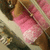 Pixelated static image of a figure in pink clothing with brown hair against a blurred background.