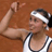 Pixelated static image of a person in athletic attire flexing an arm, wearing a headband and sleeveless top against a brown background.