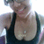 A person wearing a black tank top and silver necklace smiles broadly, with slight variations in head position across frames.