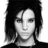 Black-and-white pixelated portrait of a person with shoulder-length dark hair, neutral expression, and visible facial features including eyes, nose, mouth, and ears.