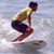 Pixelated static image of a person surfing on a board with water background.