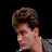 A static image featuring a pixelated character with brown hair and a gray jacket against a black background, accompanied by white text in a retro digital font.
