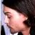 Pixelated close-up of a person's face with dark hair, light skin, and a white collar visible at the bottom edge.