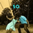 Two figures in light blue and dark clothing embrace against a blurred background with cyan text reading 'so', 'many', 'memories', '<3'