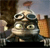 Pixelated image of a metallic robot with large eyes and a rounded body, standing against a blurred background with brown and orange tones.