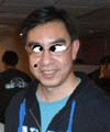 A 4-frame animated contact sheet showing a person in a blue shirt and dark jacket with changing facial features across frames, including glasses, nose dots, and eye expressions.