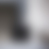 A pixelated grayscale gradient image with no distinct subjects or text, showing smooth transitions between dark gray and white tones across a square frame.