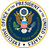 Circular seal with golden border, central blue field containing eagle holding arrows and olive branch, shield on chest, white stars above head, partial text at bottom edge.