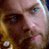 Pixelated close-up of a human face with visible eyes, nose, and mouth against a dark background with yellow highlights.