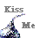 Pixelated static icon with gray text 'Kiss Me' and a colorful abstract shape resembling a kiss or splash on white background.