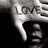 A grayscale pixelated image shows a hand with a finger pointing downward, with the word 'LOVE' partially visible above the hand.