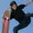 A pixelated static image shows a person in dark clothing holding a long object against a light blue background.