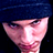 Static pixelated image of a person's face with dark blue hair and pinkish skin tones against a black background, rendered in low-resolution 256x256 pixels.