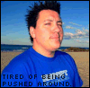 A person in a blue shirt stands on a beach with a clear sky, displaying a sequence of facial expressions while text reads "TIRED OF BEING PUSHED AROUND.".
