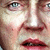 A pixelated close-up of a person's face showing eyes, nose, and mouth with visible skin tones and red lips.