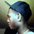 Pixelated static image of a person with dark hair wearing a blue headband, light-colored top, and dark lower garment against muted greenish background.
