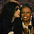 A pixelated contact sheet showing two frames of an animated icon featuring a woman with dark hair and earrings holding a microphone, next to green text reading "Original Icons .com" on a solid background.
