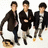Three pixelated figures in dark jackets and light pants stand side-by-side against a white background, with the leftmost figure holding an object.