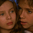 Two side-by-side faces with brown hair, light skin tones, and red lips in a pixelated static image.