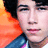 A person with dark hair and a blue jacket against an orange background, shown in three where the right eye closes then opens