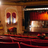 Pixelated image of a theater interior with warm lighting, featuring a stage area and seating section.