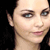 Two side-by-side pixelated images of a woman with dark hair, one with a neutral expression and the other smiling, with text below.