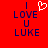 Red background with blue text reading "I LOVE U LUKE" and a white pixelated heart symbol above the word "LOVE", displayed in two identical side-by-side