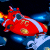 Pixelated red spaceship with white stripes and yellow accents against a dark blue background, featuring visible motion blur effects on the left side.
