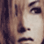Pixelated close-up of a person's face with long brown hair, showing two side-by-side views of the same individual in neutral expression.