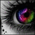 A close-up of a human eye with a rainbow-colored iris, black and white grayscale surrounding the eye, and visible eyelashes.