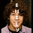 A person with curly brown hair wears a light purple shirt over a black collar, displayed in four with text overlays