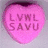 Pink heart-shaped candy with embossed text, red banner reading 'All you need is LOVE', and black-and-white striped background.