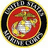 United States Marine Corps emblem with eagle, globe, and anchor on red background, surrounded by black and yellow rings, with camouflage and text elements.