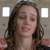 A static pixelated image of a person with long brown hair, closed eyes, and a neutral expression against a light background with two square windows.