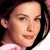 Pixelated close-up of a person's face with dark hair, light skin, and a neutral expression, wearing a light-colored top.