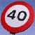 Circular red-bordered sign with white background displaying black numerals '40' against a blue gradient backdrop.