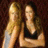 Two pixelated figures with light skin tones, one in a white sleeveless top and the other in a black sleeveless top, positioned against a dark brown background.