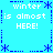 Pixelated blue background with white text reading "winter is almost HERE!" repeated four times in a , surrounded by blue asterisk and dotted-line borders
