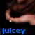A pixelated close-up of a person's arm and shoulder with a gold ring, set against a black background with blue text reading 'juicey' at the bottom.