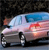 Pixelated image of a light-colored vehicle with blue and red accents, viewed from a low angle against a dark background.