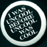 Circular icon with dark background and white border containing repeated text "I WAS UNCOOL BEFORE UNCOOL WAS COOL" in stylized silver lettering arranged in a circular pattern.