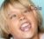 Pixelated close-up of a person's face with closed eyes and mouth open in an exaggerated expression, set against a light blue background.