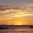 A static image with a sunset beach scene on the left and red text blocks on the right, displaying pixelated text about California and Pennsylvania.